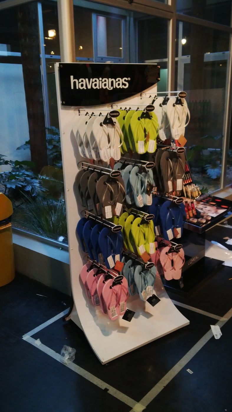 Exhibidor de piso curvo de Havaianas con ojotas colgadas