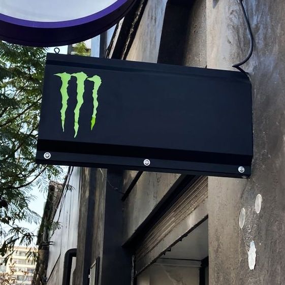 Cartel saliente de Monster Energy en una fachada